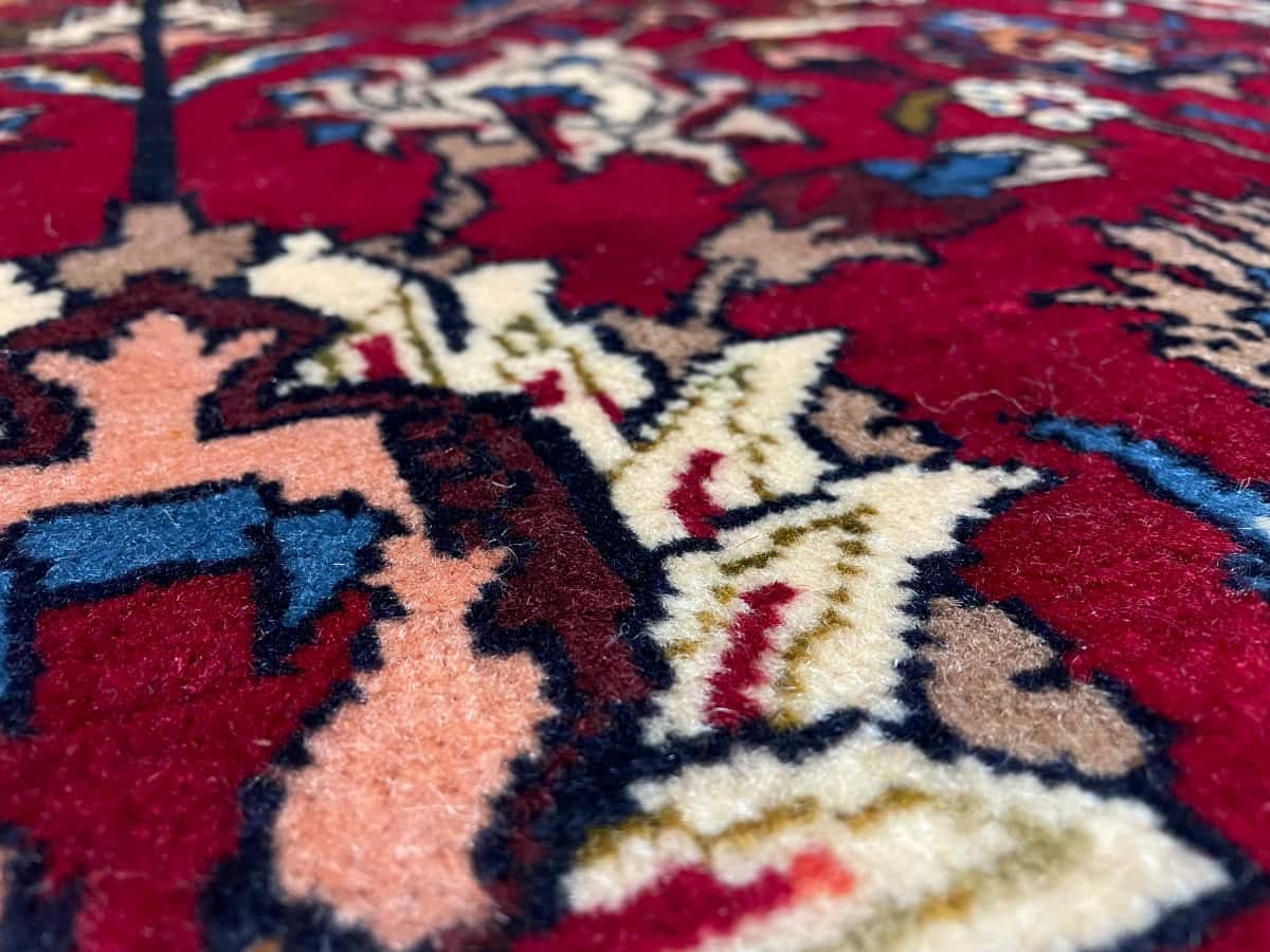 persischer Teppich im Baluch Stil in den Maßen 220 Zentimeter Länge mal 137 Zentimeter Breite mit überwiegend rot und blau Farben — Nahaufnahme der Textur