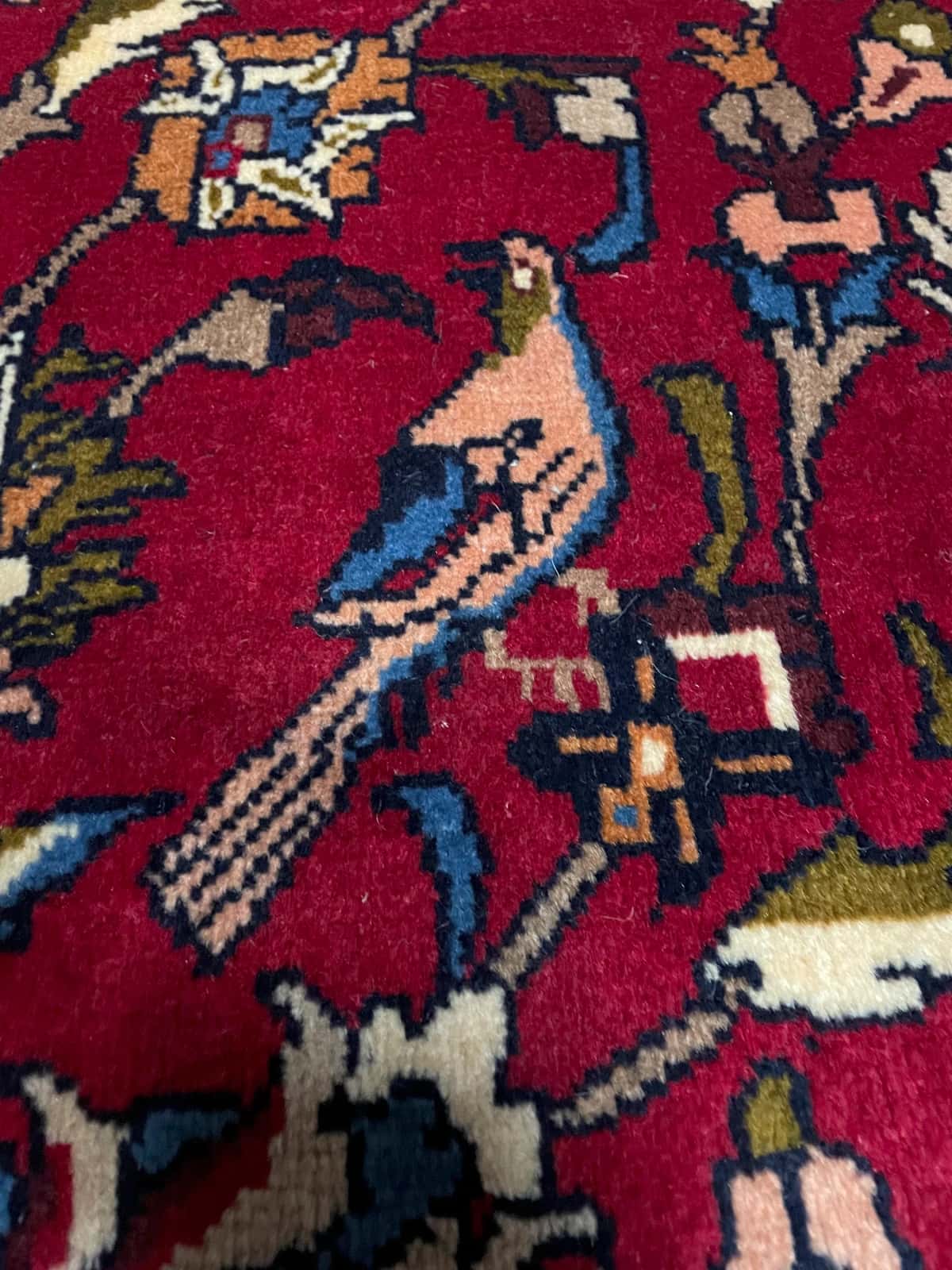 persischer Teppich im Baluch Stil in den Maßen 220 Zentimeter Länge mal 137 Zentimeter Breite mit überwiegend rot und blau Farben — Nahaufnahme der Textur