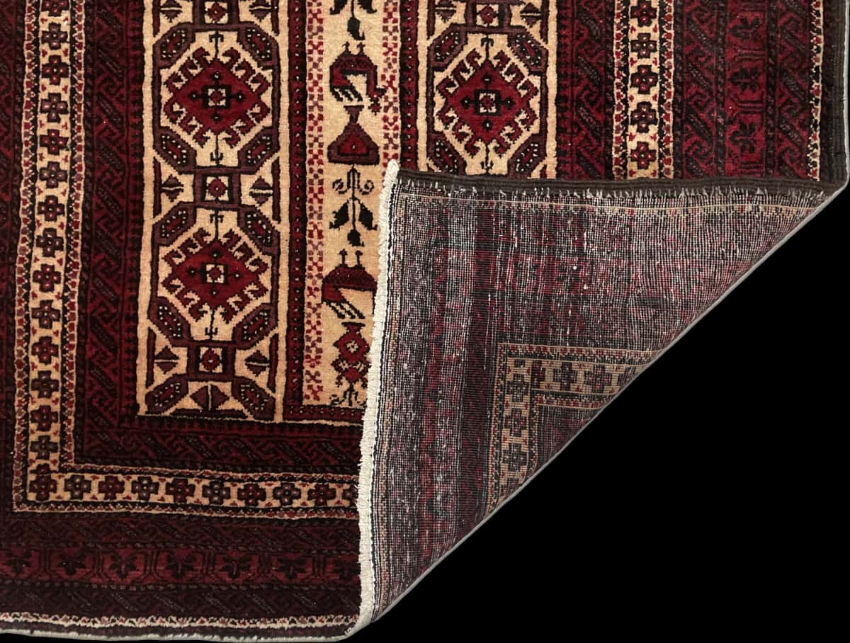 Persian rug of Baluch style in dimensions 205 centimeters length by 108 centimeters width with mainly red colors — Folded