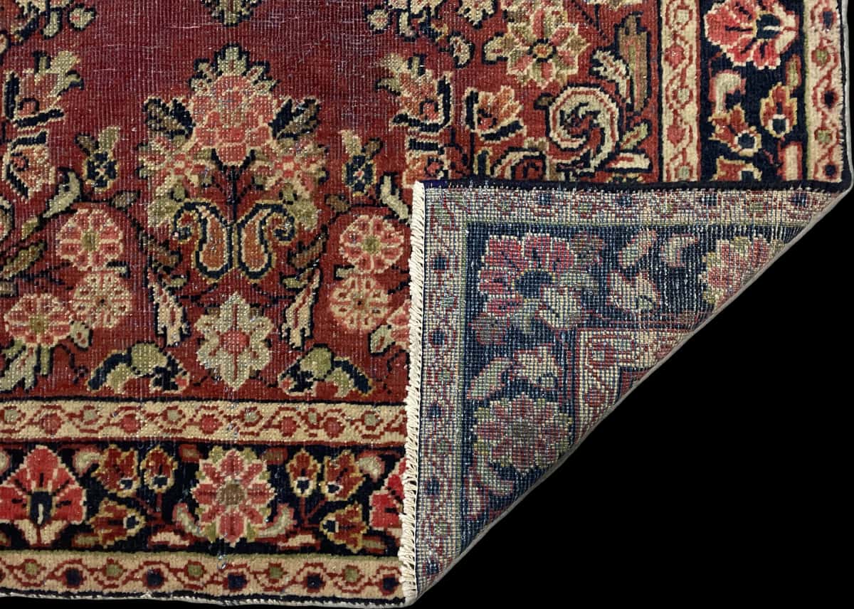 alfombra persa de estilo Moshkabad en dimensiones 198 centímetros de largo por 124 centímetros de ancho con colores principalmente morado — Plegada