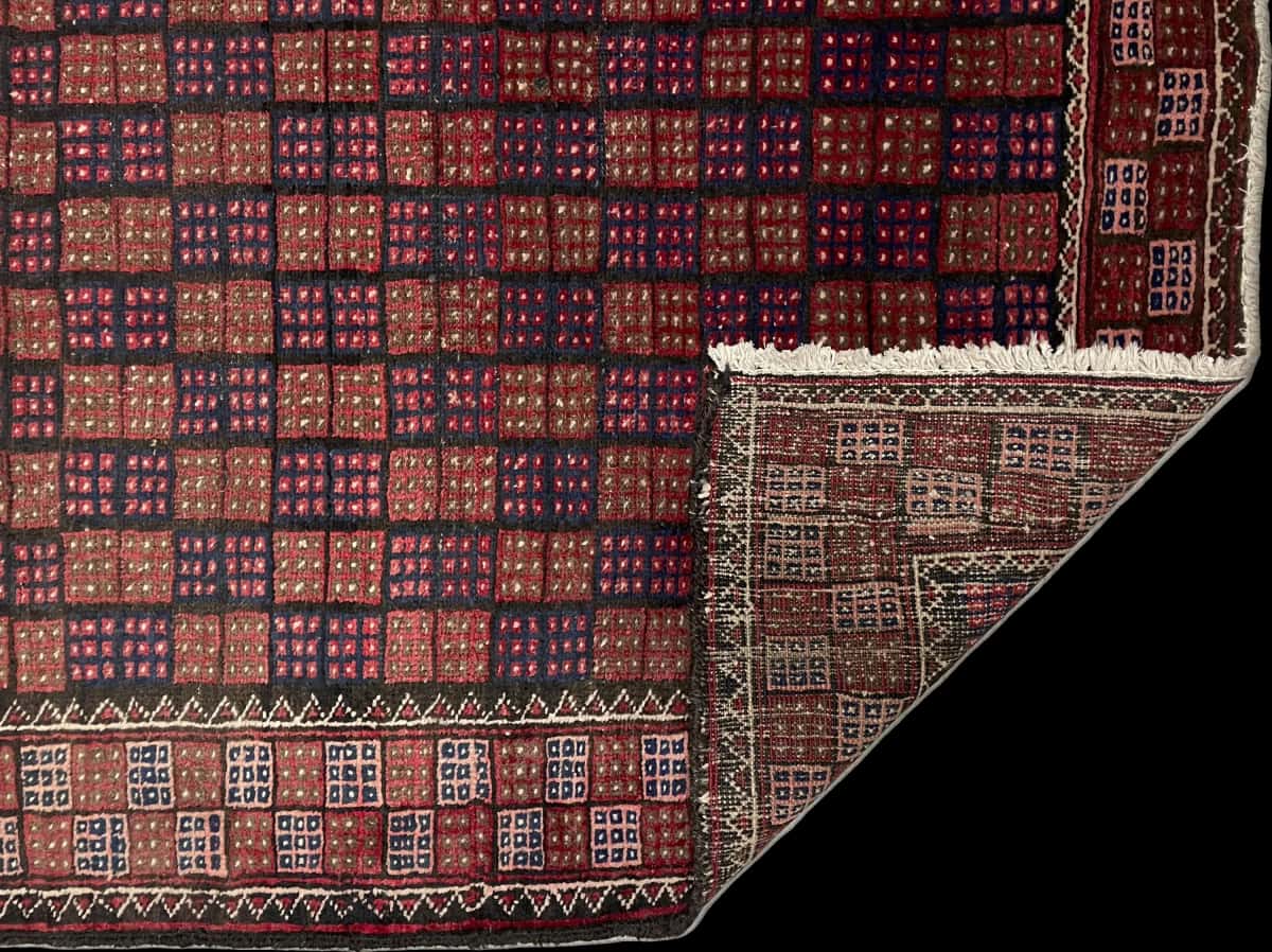 alfombra persa de estilo baluch en dimensiones 170 centímetros de largo por 93 centímetros de ancho con colores principalmente marrón y azul — Plegada