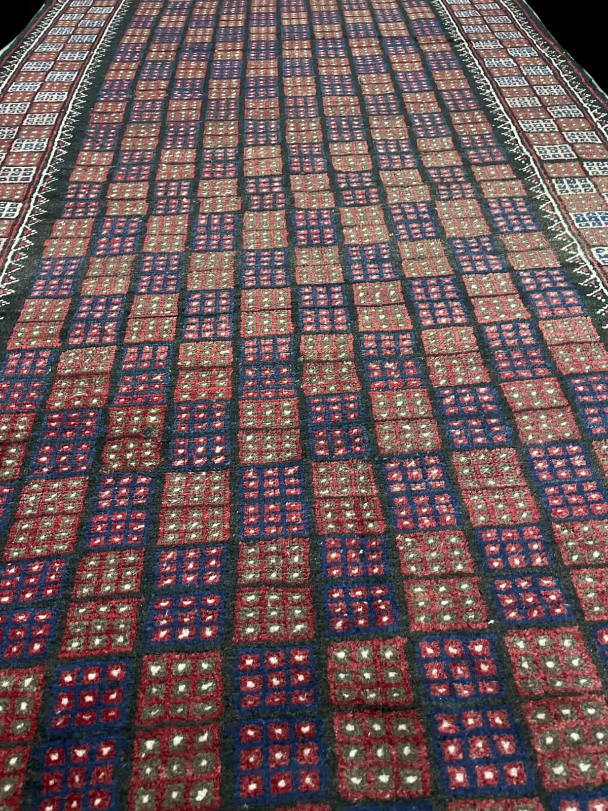 alfombra persa de estilo baluch en dimensiones 170 centímetros de largo por 93 centímetros de ancho con colores principalmente marrón y azul — Perspectiva