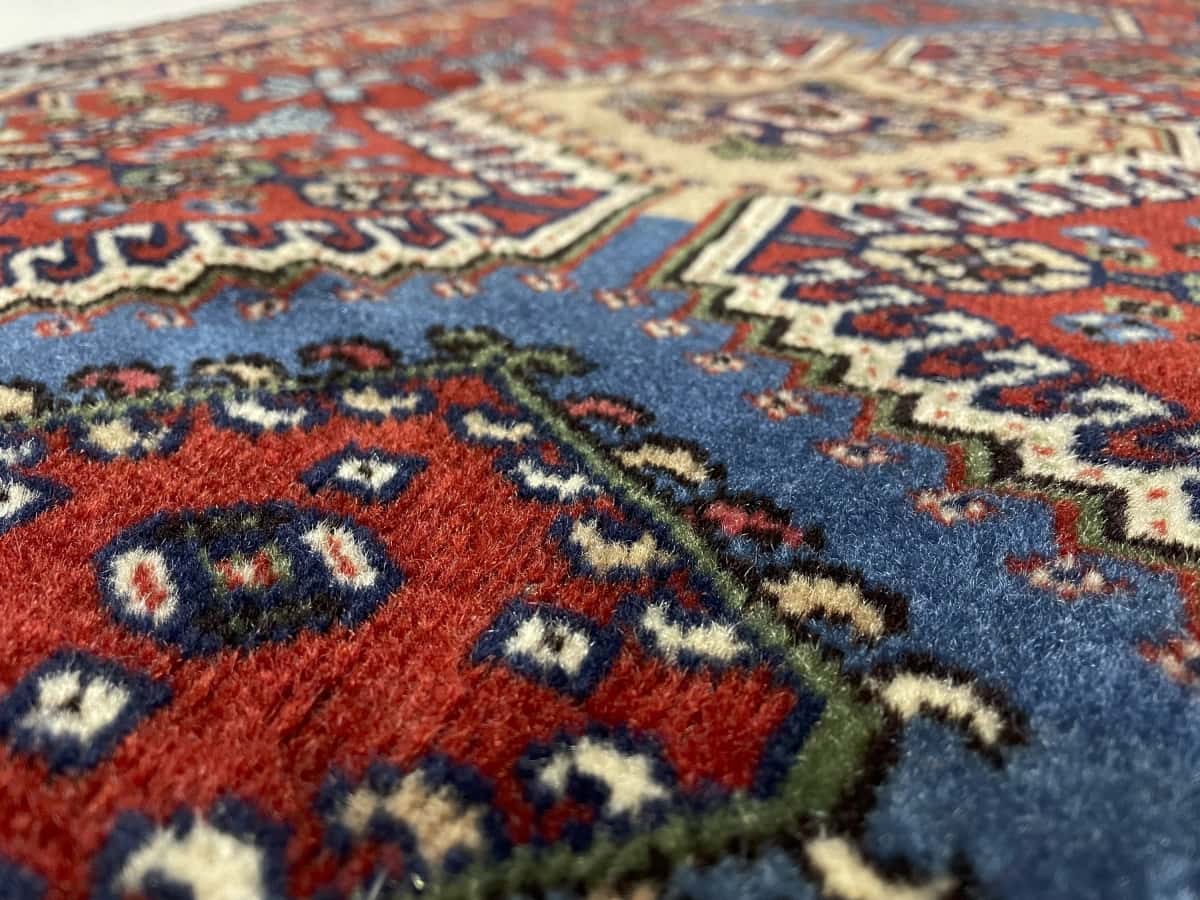 alfombra persa de estilo bakhtiari en dimensiones 148 centímetros de largo por 85 centímetros de ancho con colores principalmente azul y naranja — Primer plano de la textura