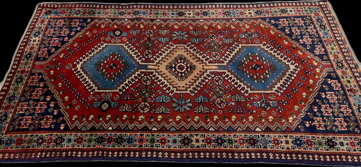 persischer Teppich im Bakhtiari Stil in den Maßen 148 Zentimeter Länge mal 85 Zentimeter Breite mit überwiegend blau und orange Farben — Perspektive