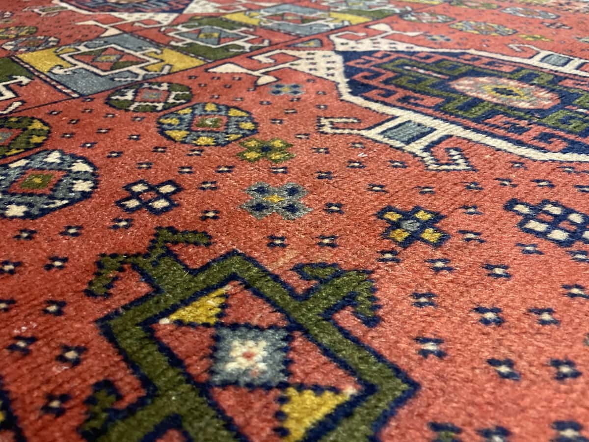 Persian rug of Quchan style in dimensions 202 centimeters length by 108 centimeters width with mainly red and blue colors — Texture close-up