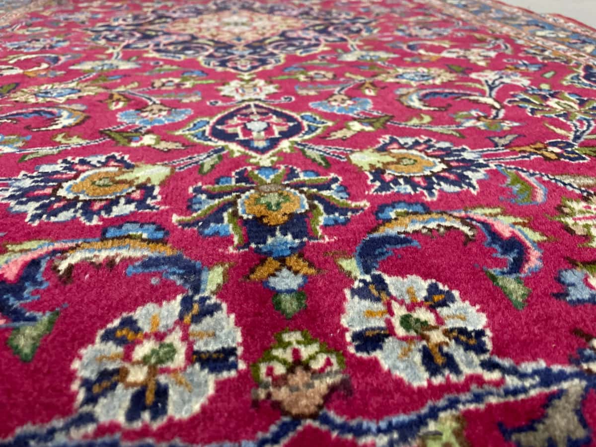 persischer Teppich im Kashmar Stil in den Maßen 217 Zentimeter Länge mal 110 Zentimeter Breite mit überwiegend rot und blau Farben — Nahaufnahme der Textur