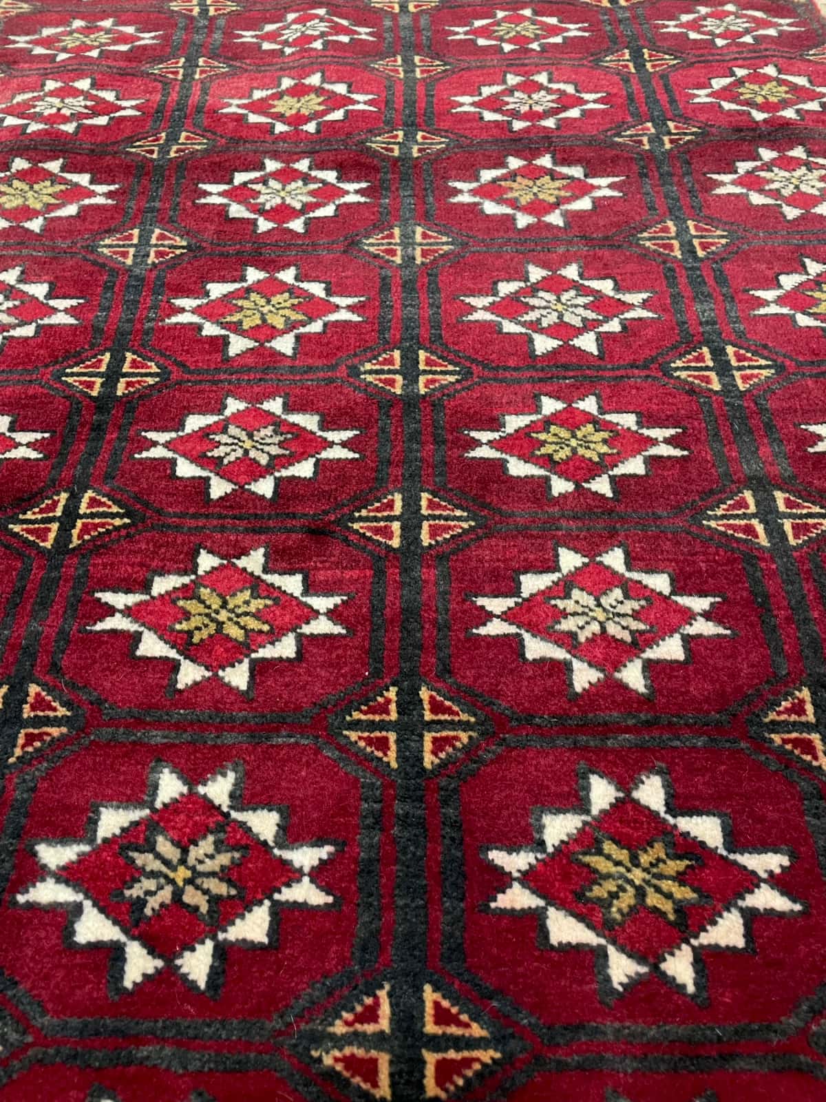 persischer Teppich im Baluch Stil in den Maßen 150 Zentimeter Länge mal 92 Zentimeter Breite mit überwiegend rot Farben — Nahaufnahme der Textur