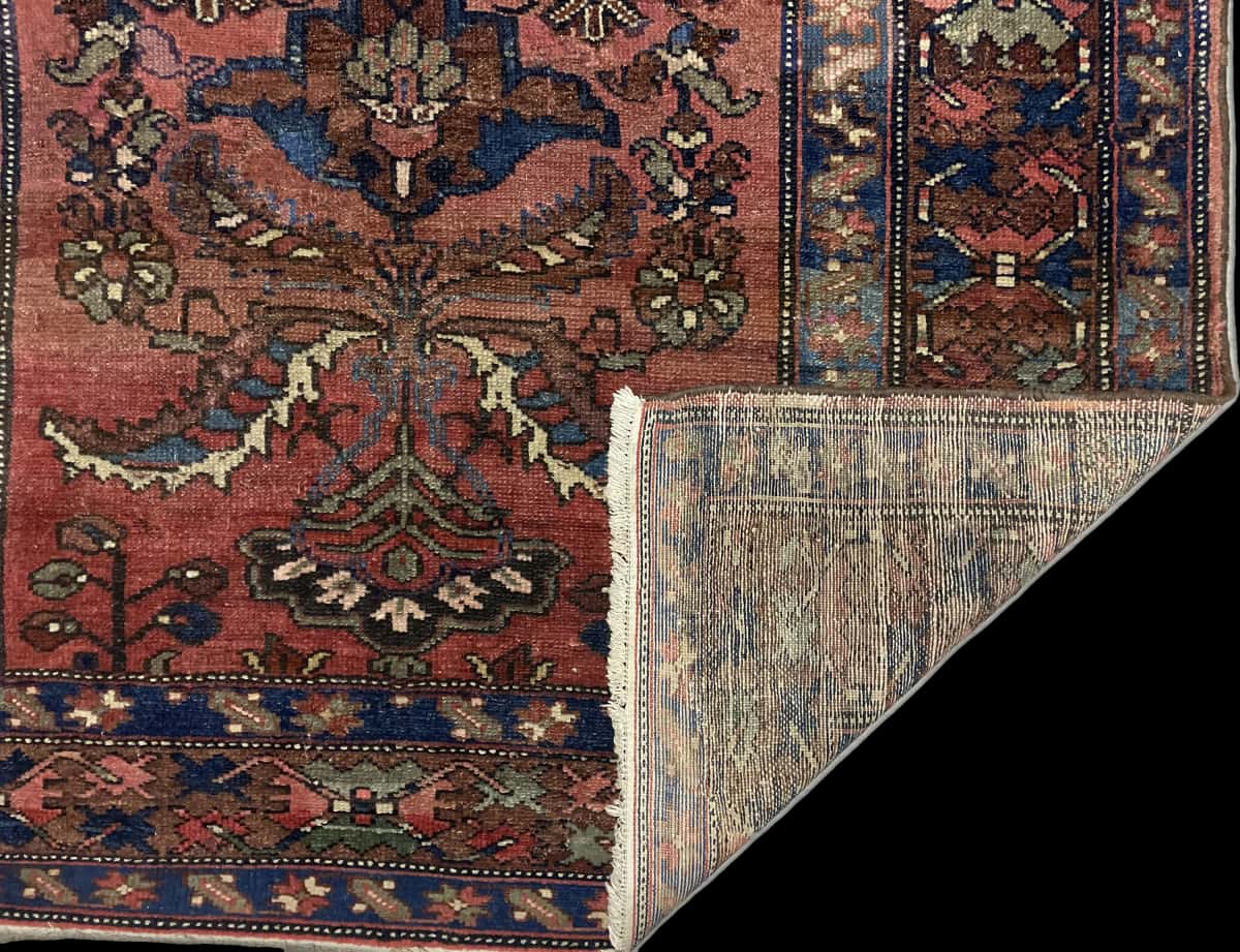 alfombra persa de estilo bakhtiari en dimensiones 200 centímetros de largo por 137 centímetros de ancho con colores principalmente rojo — Plegada