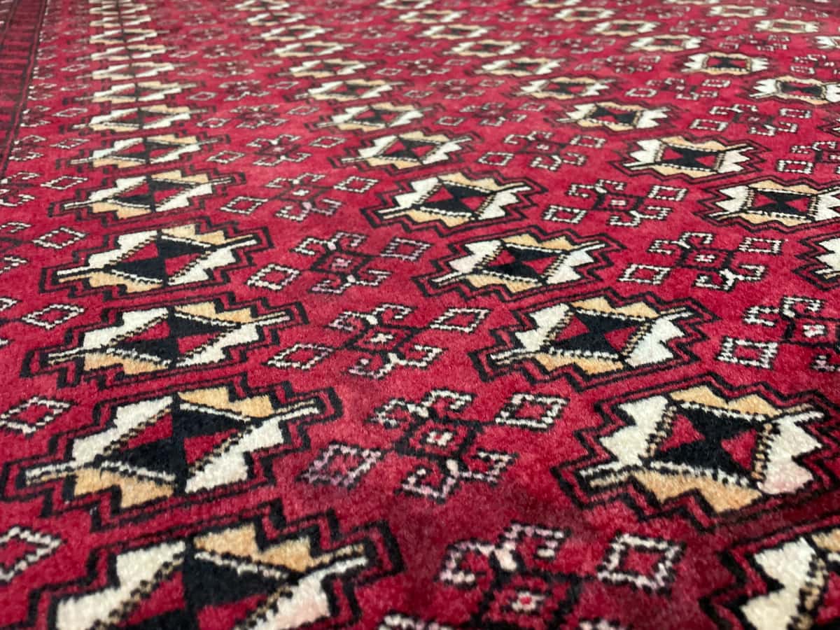 persischer Teppich im Baluch Stil in den Maßen 204 Zentimeter Länge mal 116 Zentimeter Breite mit überwiegend rot Farben — Nahaufnahme der Textur