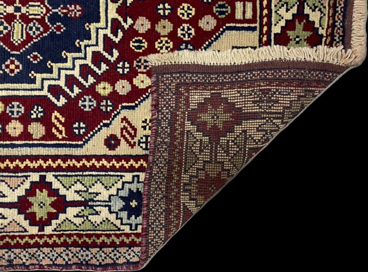 Persian rug of Baluch style in dimensions 145 centimeters length by 103 centimeters width with mainly beige and red colors — Folded