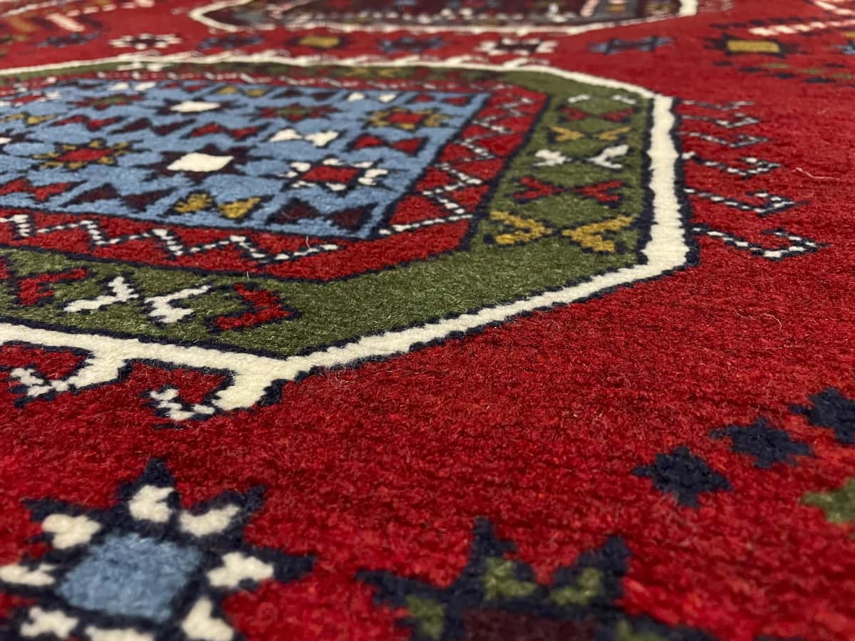 alfombra persa de estilo Quchan en dimensiones 165 centímetros de largo por 130 centímetros de ancho con colores principalmente rojo — Primer plano de la textura