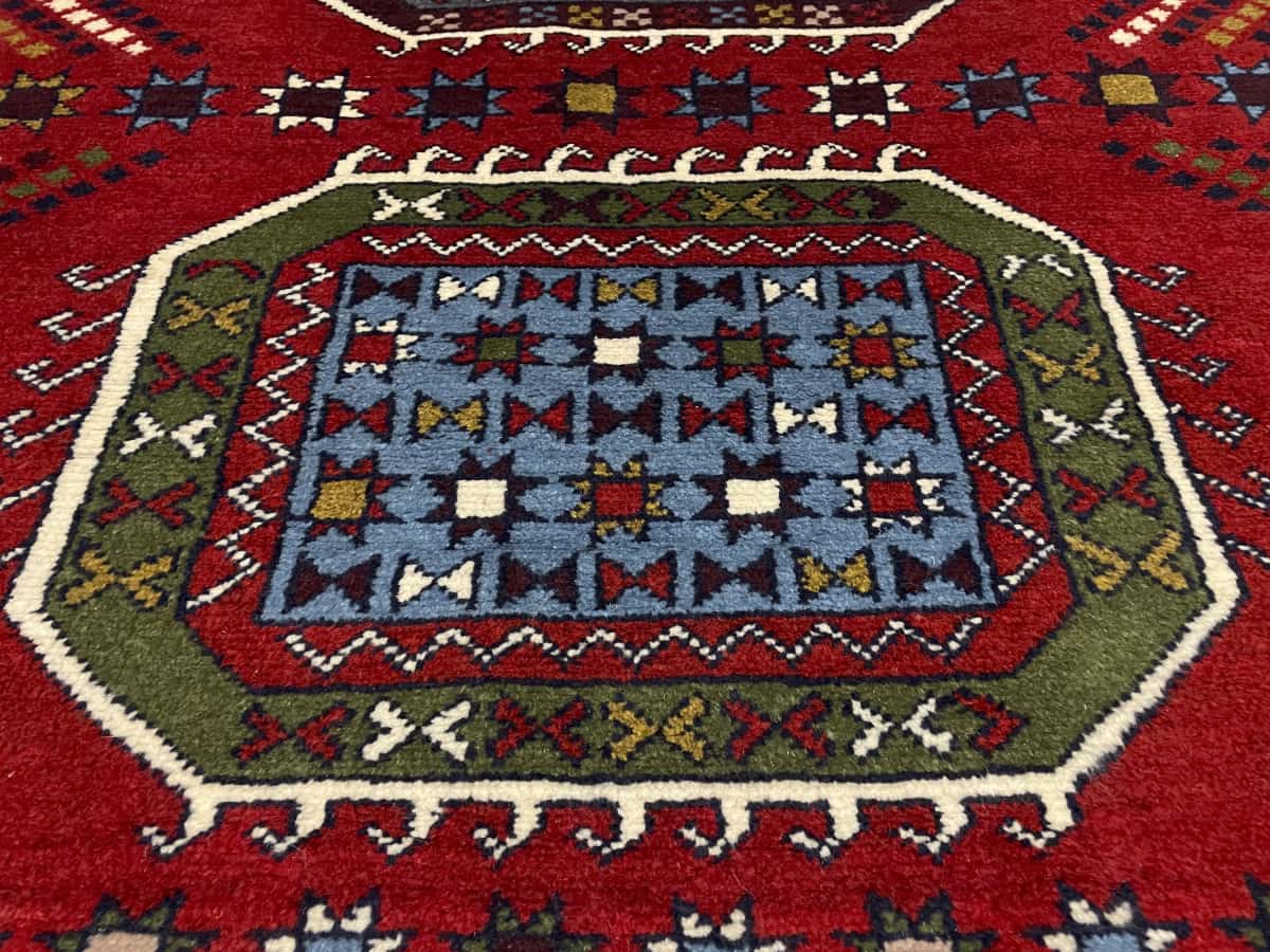 alfombra persa de estilo Quchan en dimensiones 165 centímetros de largo por 130 centímetros de ancho con colores principalmente rojo — Primer plano de la textura