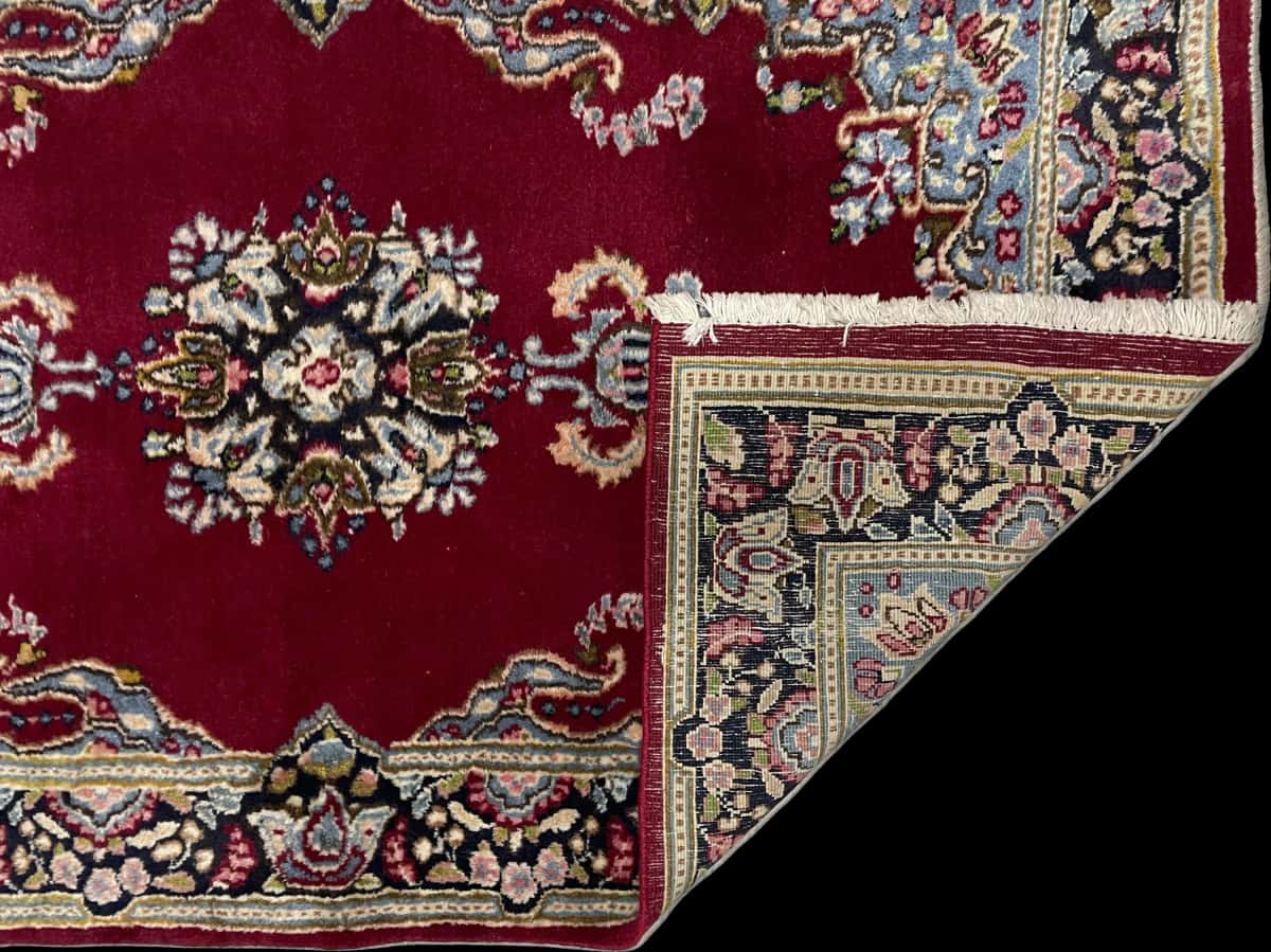 Persian rug of Kerman style in dimensions 145 centimeters length by 88 centimeters width with mainly red and blue colors — Folded
