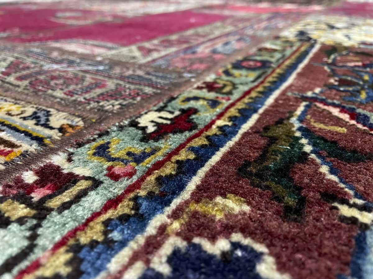Persian rug of Kerman style in dimensions 145 centimeters length by 88 centimeters width with mainly red and blue colors — Texture close-up