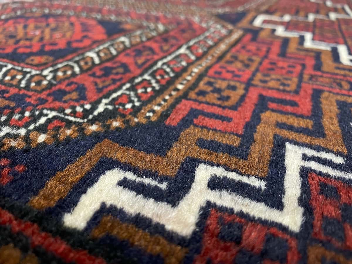 Persian rug of Turkoman style in dimensions 162 centimeters length by 87 centimeters width with mainly red colors — Texture close-up