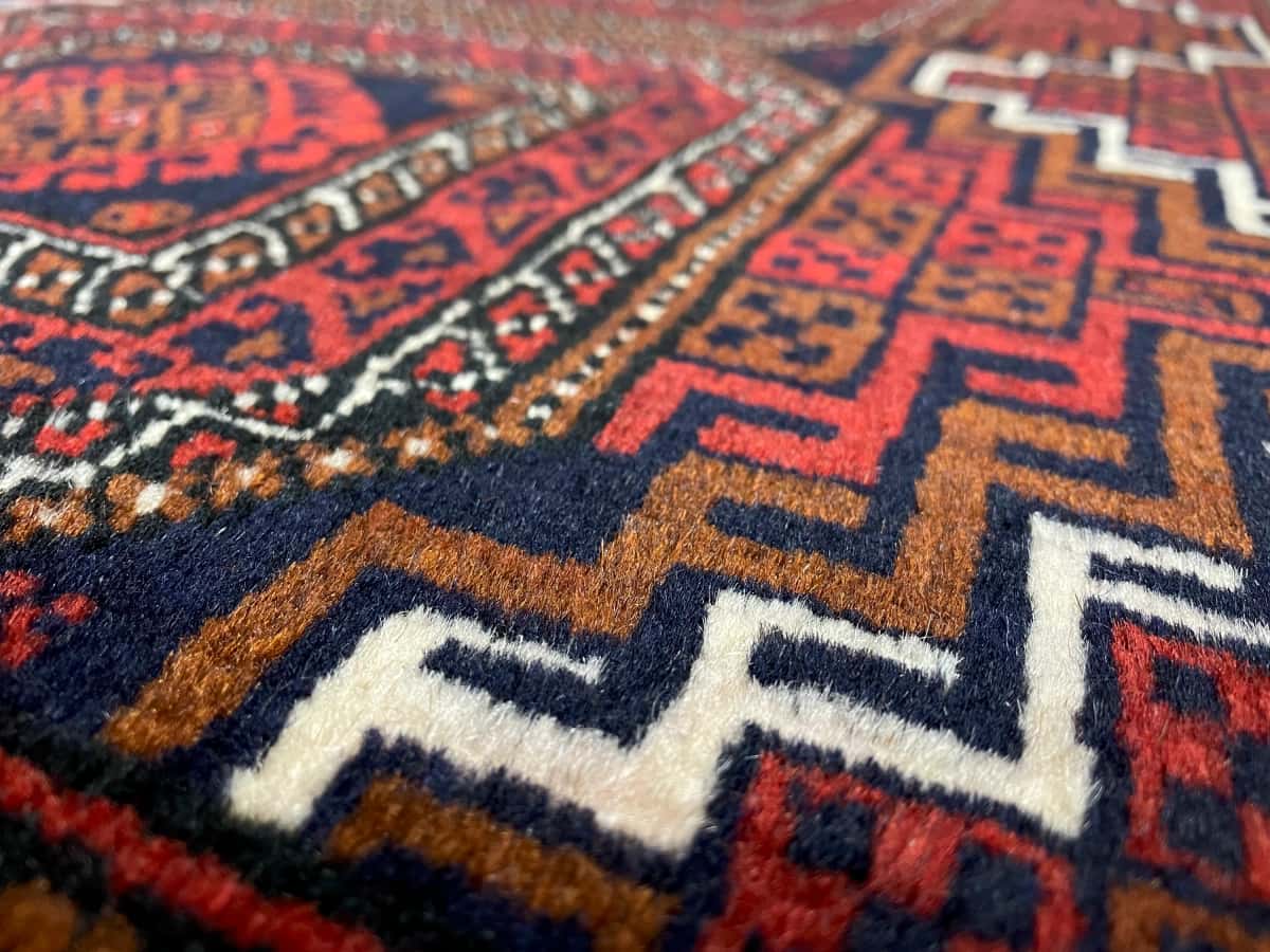 Persian rug of Turkoman style in dimensions 162 centimeters length by 87 centimeters width with mainly red colors — Texture close-up