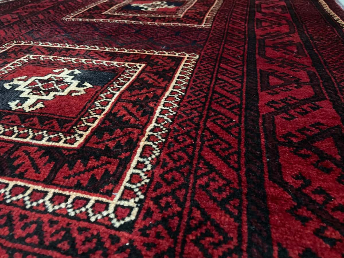 persischer Teppich im Baluch Stil in den Maßen 198 Zentimeter Länge mal 110 Zentimeter Breite mit überwiegend rot Farben — Nahaufnahme der Textur