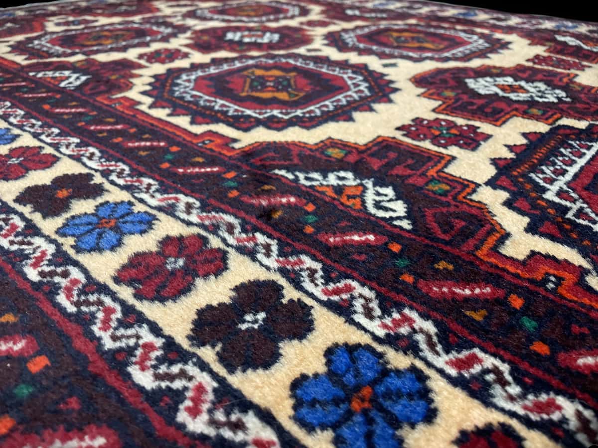 Persian rug of Baluch style in dimensions 193 centimeters length by 100 centimeters width with mainly red and orange colors — Texture close-up