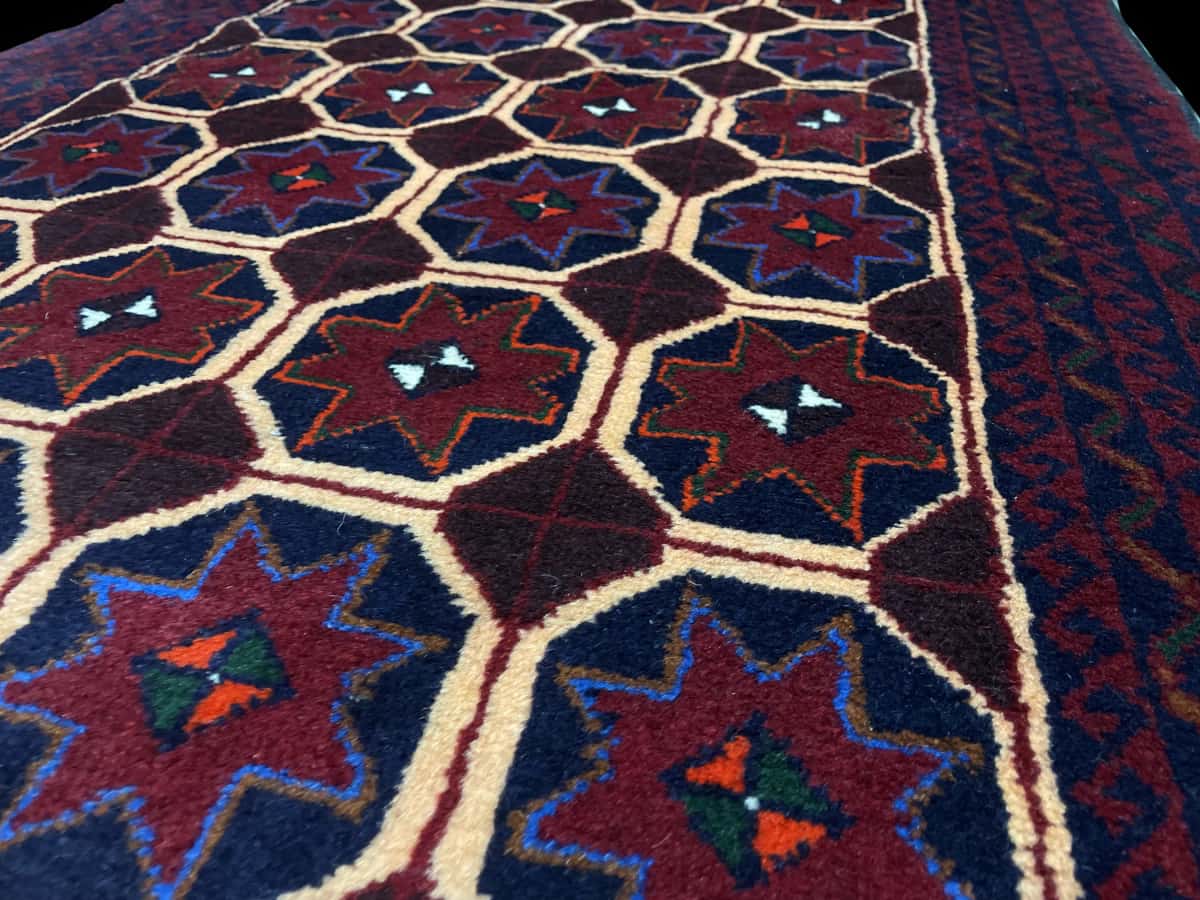 Persian rug of Baluch style in dimensions 190 centimeters length by 95 centimeters width with mainly red and blue colors — Texture close-up