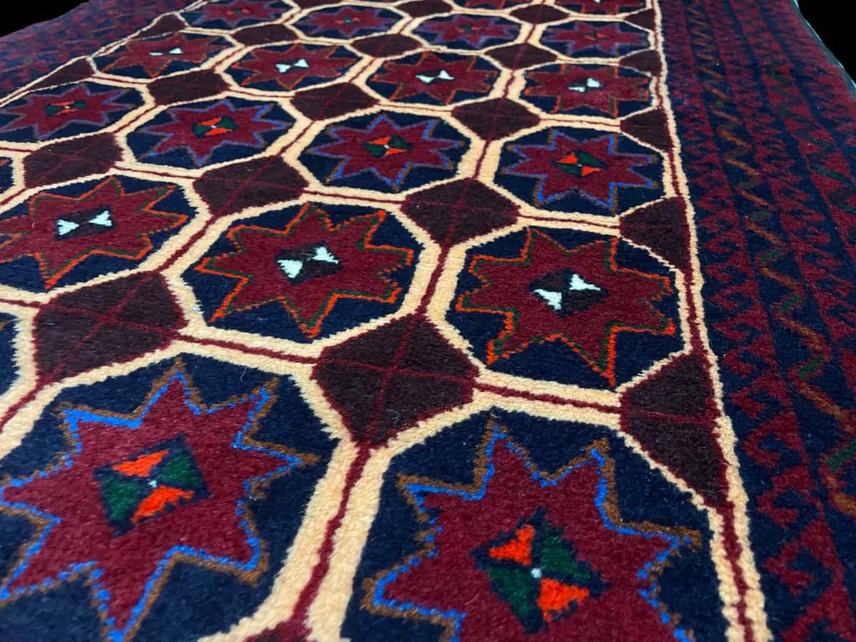 Persian rug of Baluch style in dimensions 190 centimeters length by 95 centimeters width with mainly red and blue colors — Texture close-up