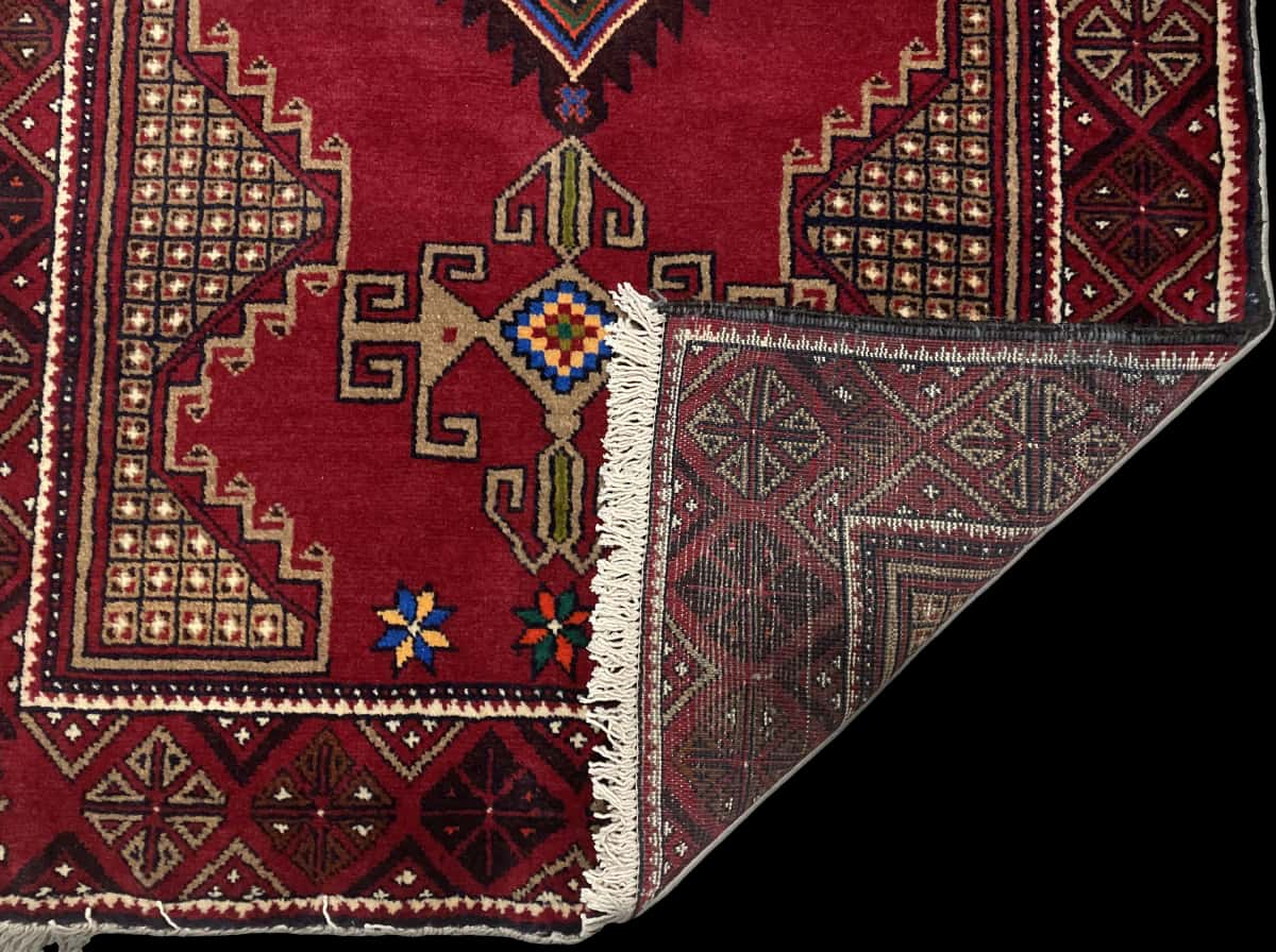 Persian rug of Baluch style in dimensions 195 centimeters length by 100 centimeters width with mainly red colors — Folded