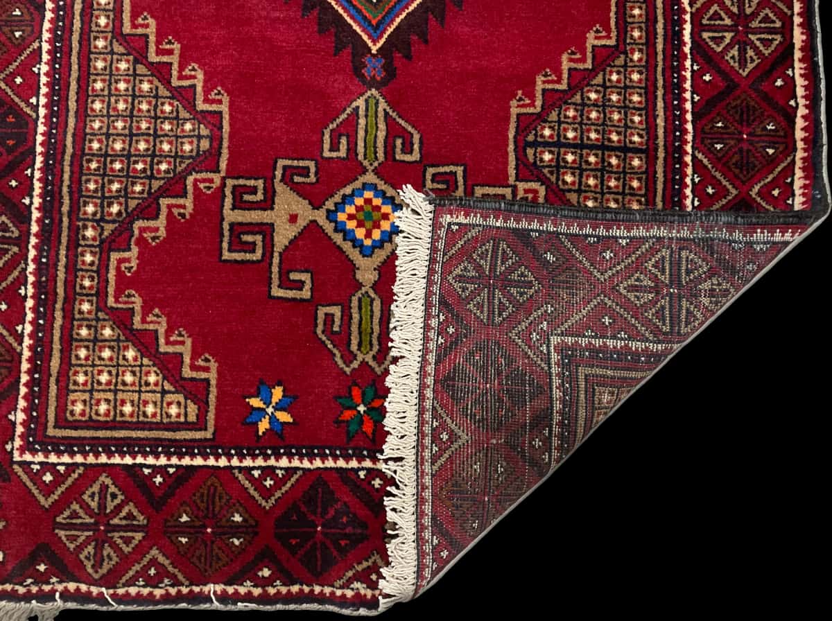 Persian rug of Baluch style in dimensions 195 centimeters length by 100 centimeters width with mainly red colors — Folded