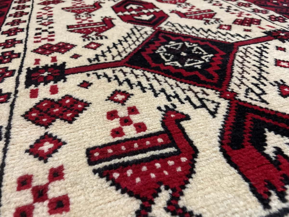 Persian rug of Baluch style in dimensions 187 centimeters length by 106 centimeters width with mainly beige and red colors — Texture close-up