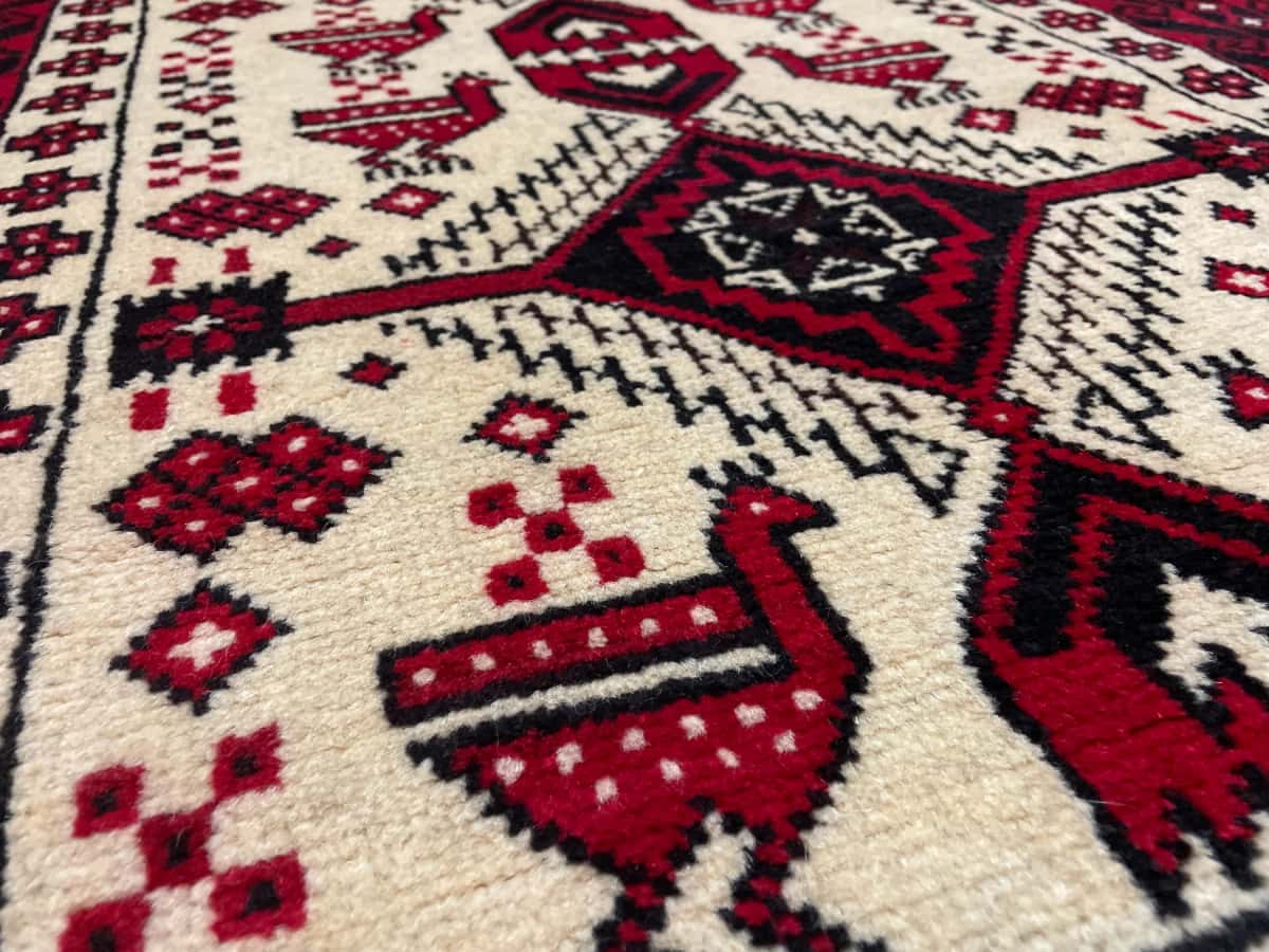 persischer Teppich im Baluch Stil in den Maßen 187 Zentimeter Länge mal 106 Zentimeter Breite mit überwiegend beige und rot Farben — Nahaufnahme der Textur