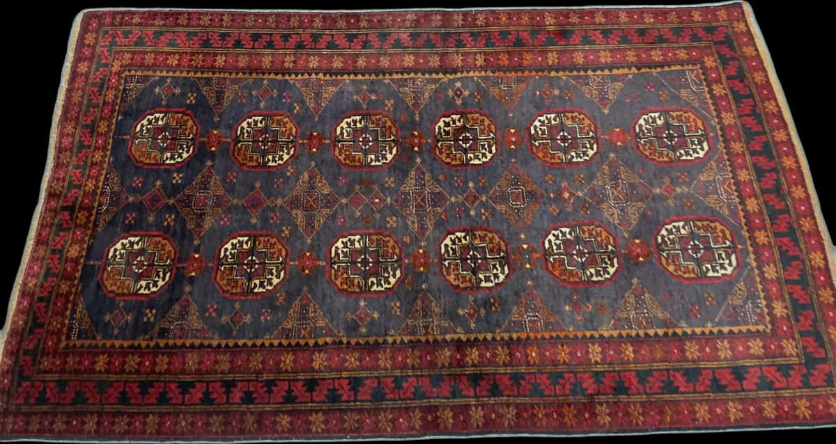 alfombra persa de estilo baluch en dimensiones 188 centímetros de largo por 116 centímetros de ancho con colores principalmente rojo — Perspectiva