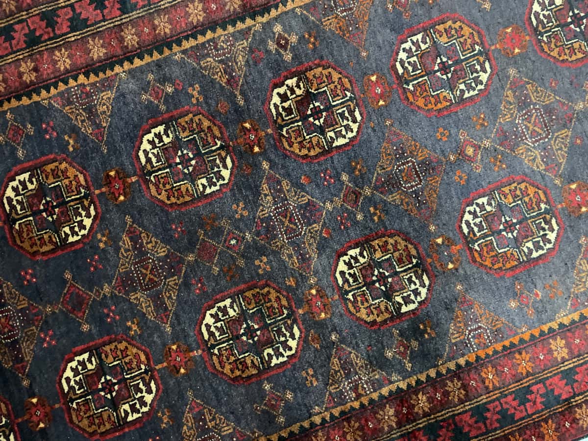 alfombra persa de estilo baluch en dimensiones 188 centímetros de largo por 116 centímetros de ancho con colores principalmente rojo — Perspectiva