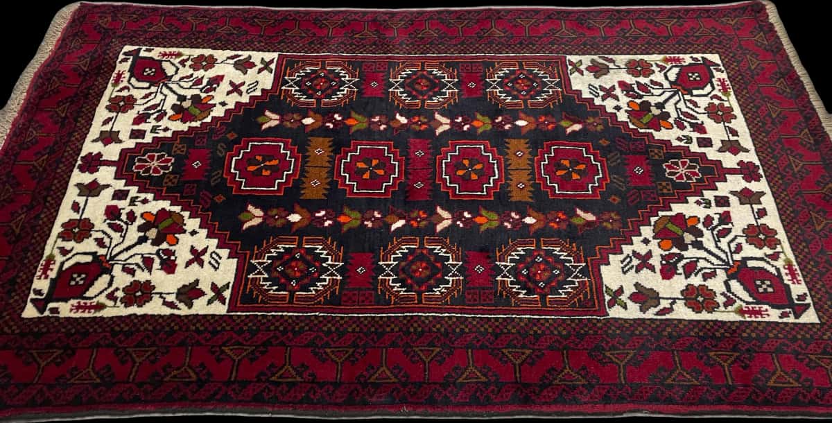 alfombra persa de estilo baluch en dimensiones 170 centímetros de largo por 103 centímetros de ancho con colores principalmente rojo — Perspectiva