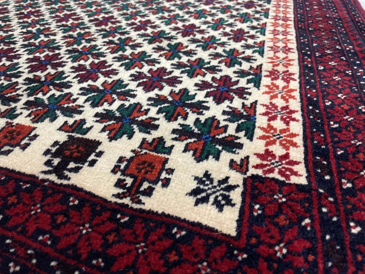 Persian rug of Baluch style in dimensions 182 centimeters length by 100 centimeters width with mainly red colors — Texture close-up