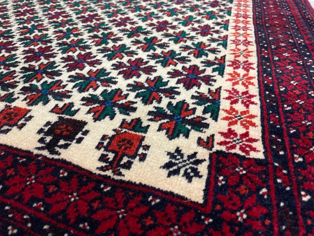 persischer Teppich im Baluch Stil in den Maßen 182 Zentimeter Länge mal 100 Zentimeter Breite mit überwiegend rot Farben — Nahaufnahme der Textur