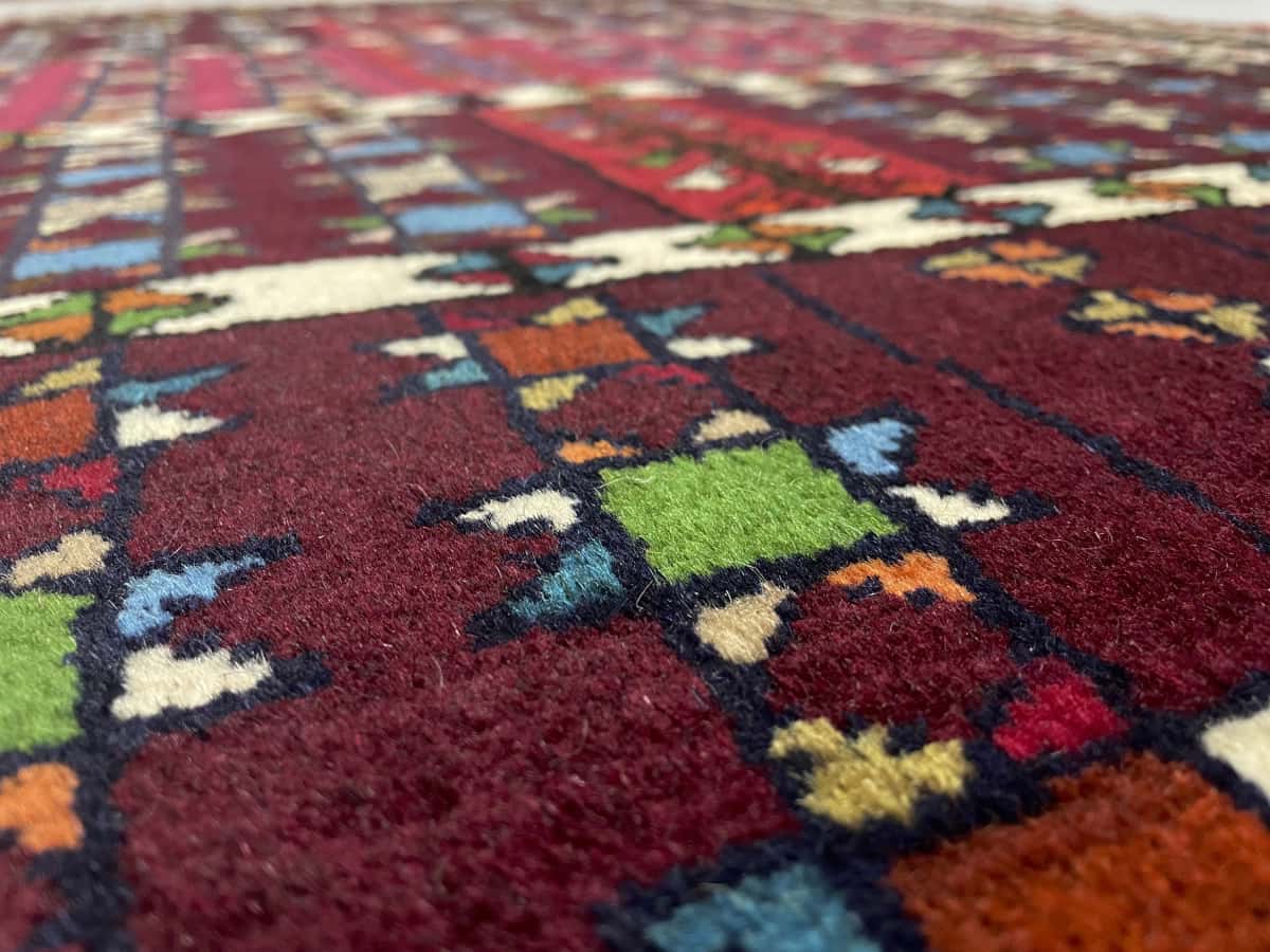 Persian rug of Quchan style in dimensions 171 centimeters length by 118 centimeters width with mainly red and brown colors — Texture close-up