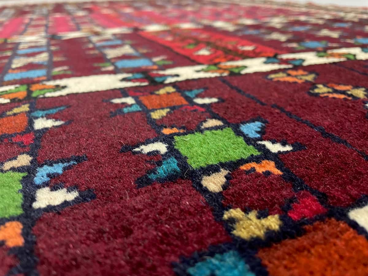 persischer Teppich im Quchan Stil in den Maßen 171 Zentimeter Länge mal 118 Zentimeter Breite mit überwiegend rot und braun Farben — Nahaufnahme der Textur