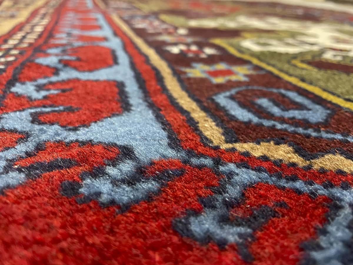 Persian rug of Quchan style in dimensions 172 centimeters length by 117 centimeters width with mainly red and green colors — Texture close-up