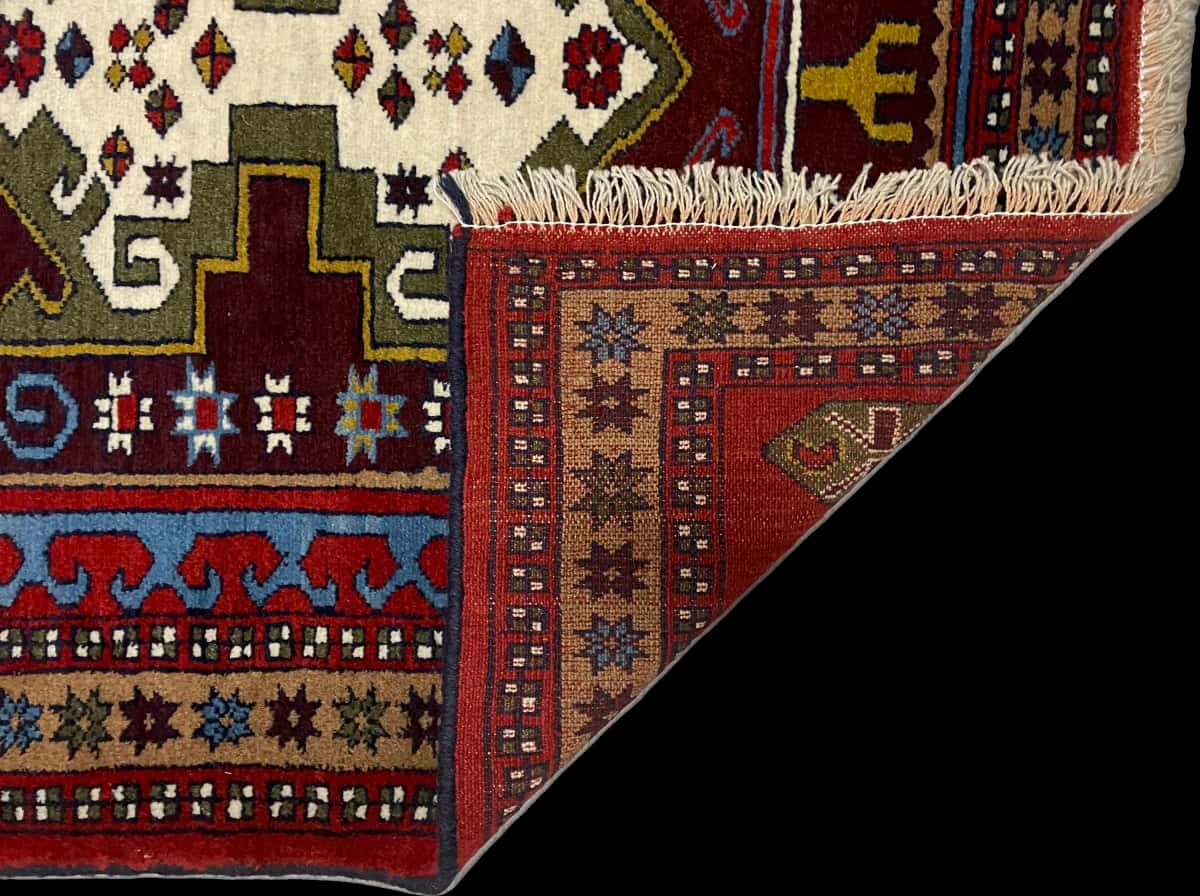 persischer Teppich im Quchan Stil in den Maßen 172 Zentimeter Länge mal 117 Zentimeter Breite mit überwiegend rot und grün Farben — Gefaltet