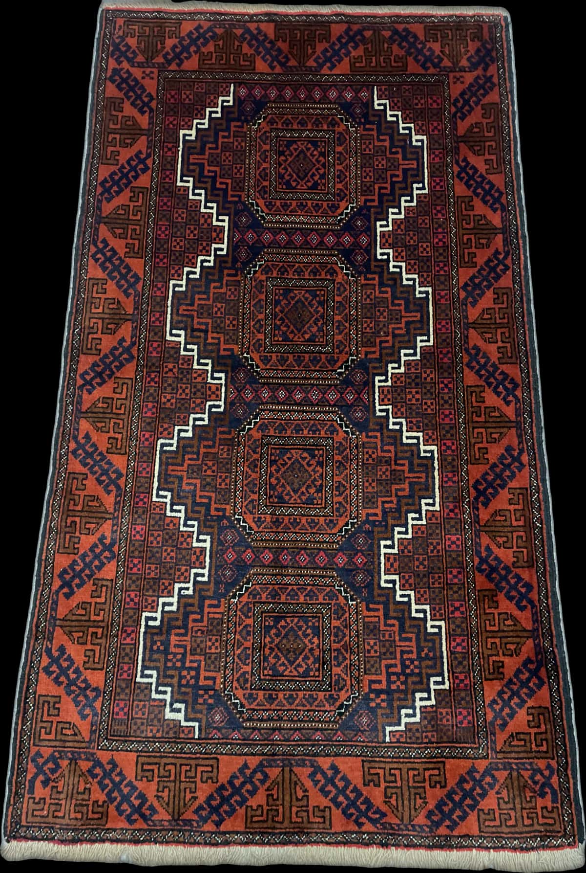 alfombra persa de estilo baluch en dimensiones 180 centímetros de largo por 98 centímetros de ancho con colores principalmente naranja y azul — Perspectiva