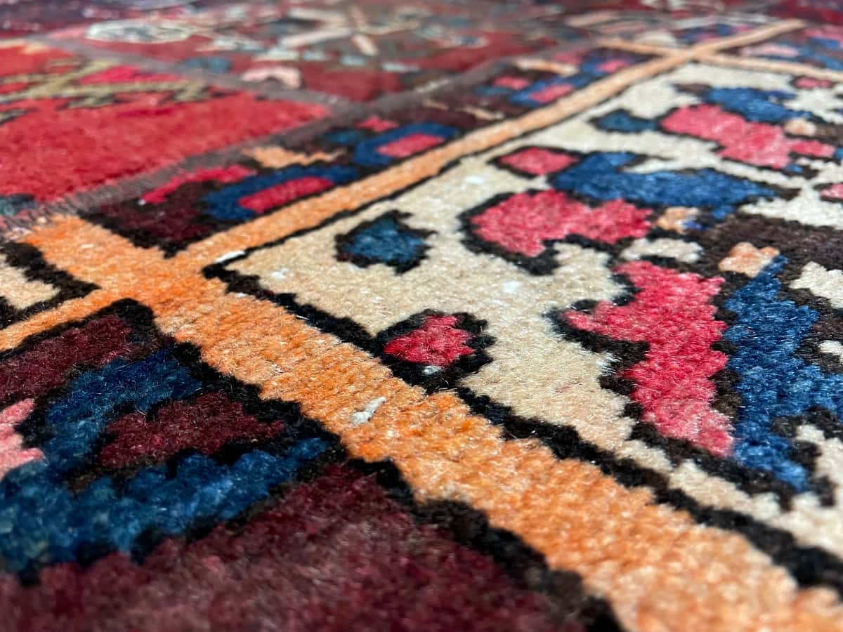 Persian rug of Rey style in dimensions 207 centimeters length by 136 centimeters width with mainly red and blue colors — Texture close-up