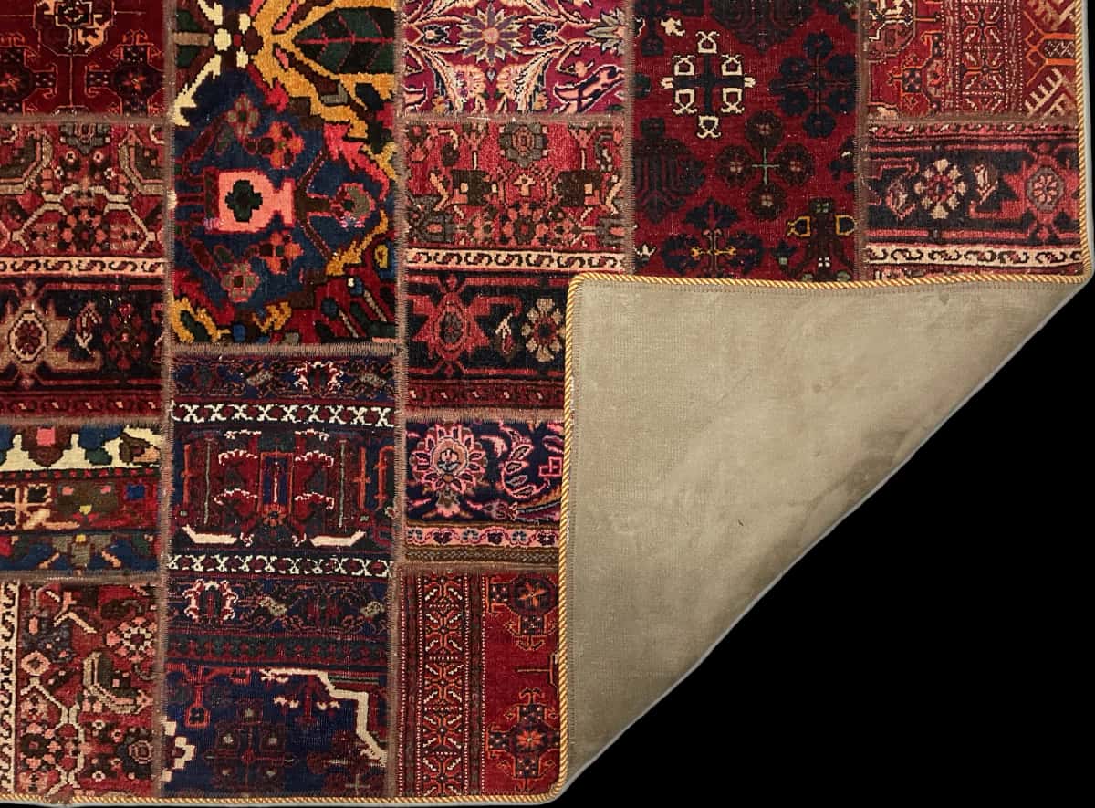 alfombra persa de estilo patchwork en dimensiones 179 centímetros de largo por 119 centímetros de ancho con colores principalmente rojo — Plegada