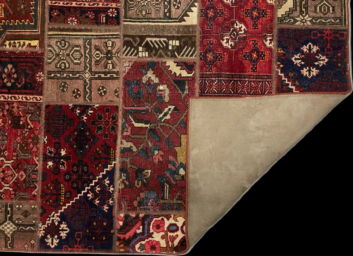 alfombra persa de estilo patchwork en dimensiones 176 centímetros de largo por 118 centímetros de ancho con colores principalmente rojo — Plegada