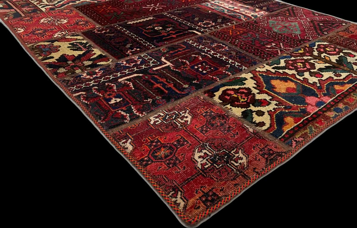 alfombra persa de estilo patchwork en dimensiones 179 centímetros de largo por 116 centímetros de ancho con colores principalmente rojo — Esquina y borde