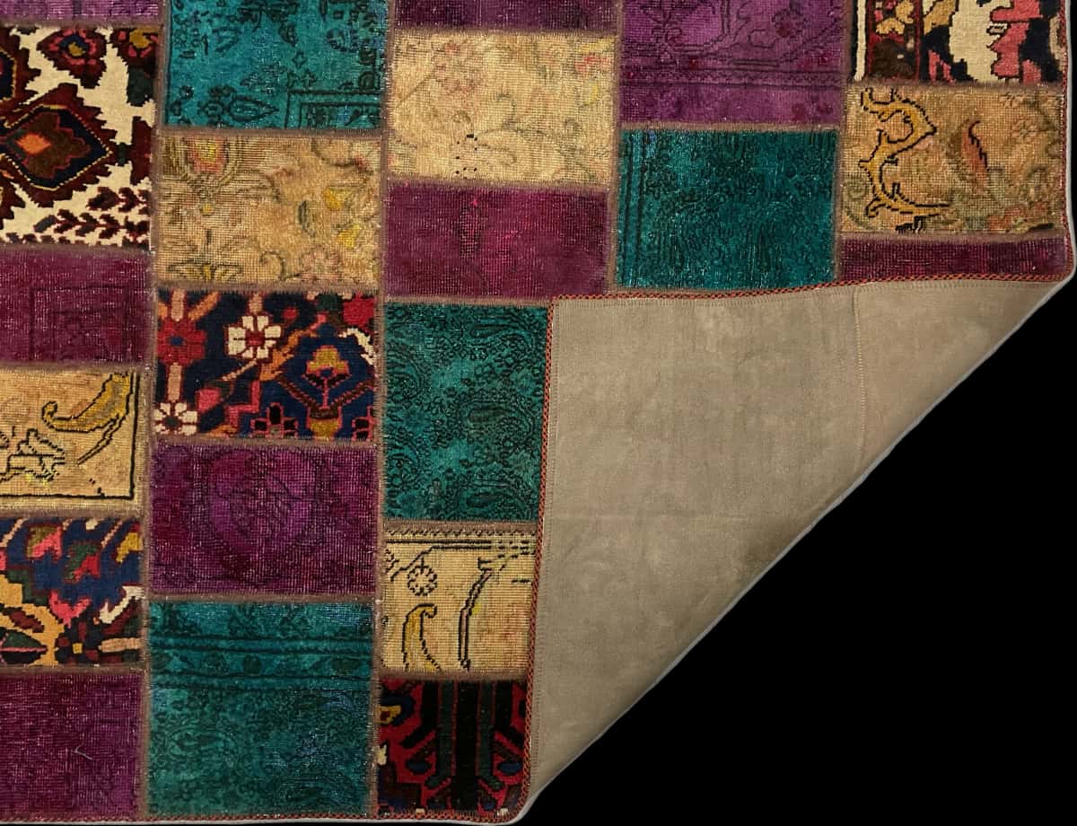 alfombra persa de estilo patchwork en dimensiones 180 centímetros de largo por 120 centímetros de ancho con colores principalmente morado y turquesa — Plegada