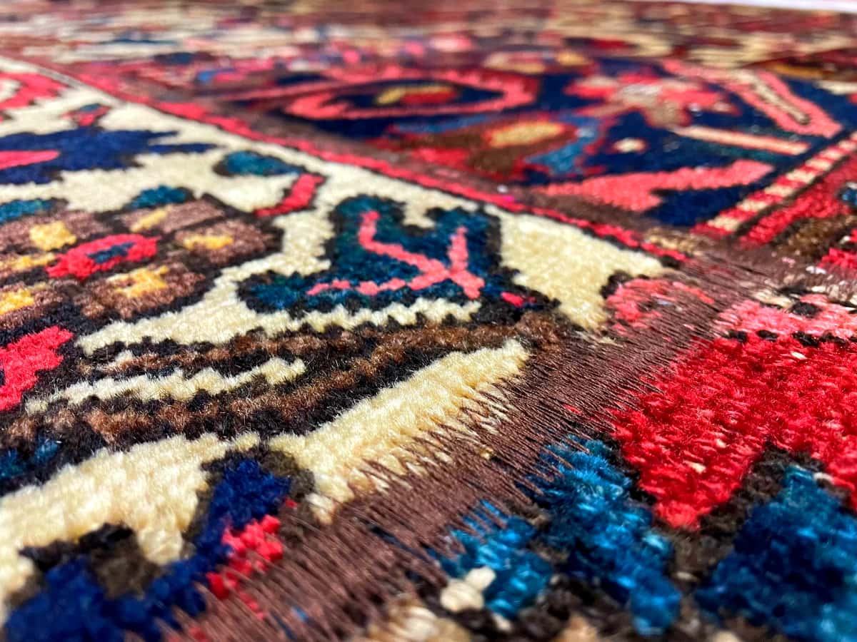 Persian rug of Rey style in dimensions 207 centimeters length by 150 centimeters width with mainly red and beige colors — Texture close-up