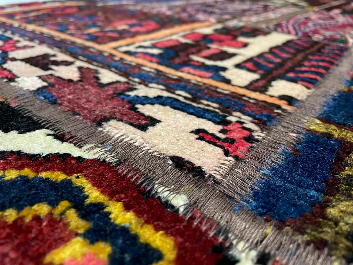 Persian rug of Rey style in dimensions 210 centimeters length by 139 centimeters width with mainly red colors — Texture close-up