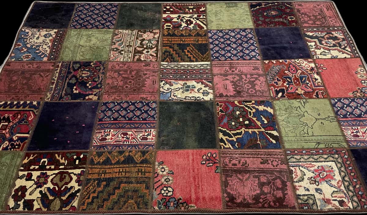 alfombra persa de estilo patchwork en dimensiones 212 centímetros de largo por 151 centímetros de ancho con colores principalmente rojo y verde — Perspectiva