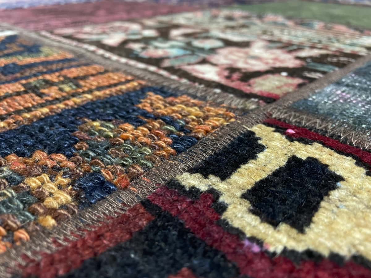 alfombra persa de estilo patchwork en dimensiones 212 centímetros de largo por 151 centímetros de ancho con colores principalmente rojo y verde — Primer plano de la textura