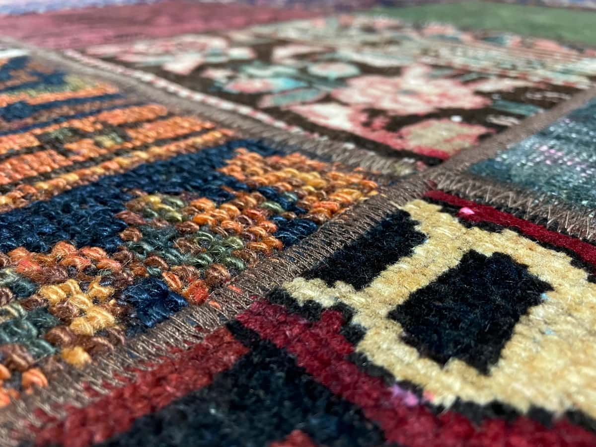 persischer Teppich im Rey Stil in den Maßen 212 Zentimeter Länge mal 151 Zentimeter Breite mit überwiegend rot und grün Farben — Nahaufnahme der Textur