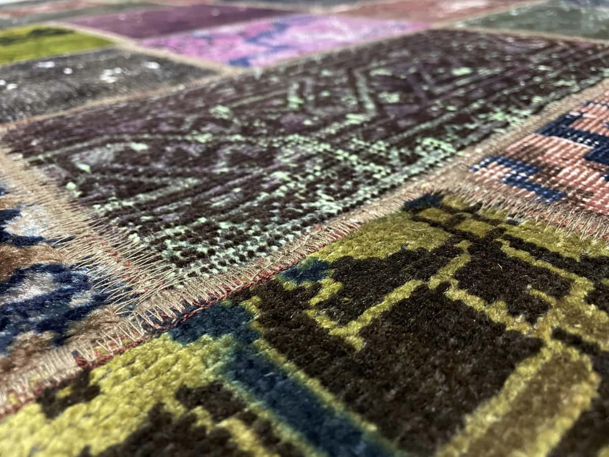Persian rug of Patchwork style in dimensions 220 centimeters length by 168 centimeters width with mainly colorful colors — Texture close-up