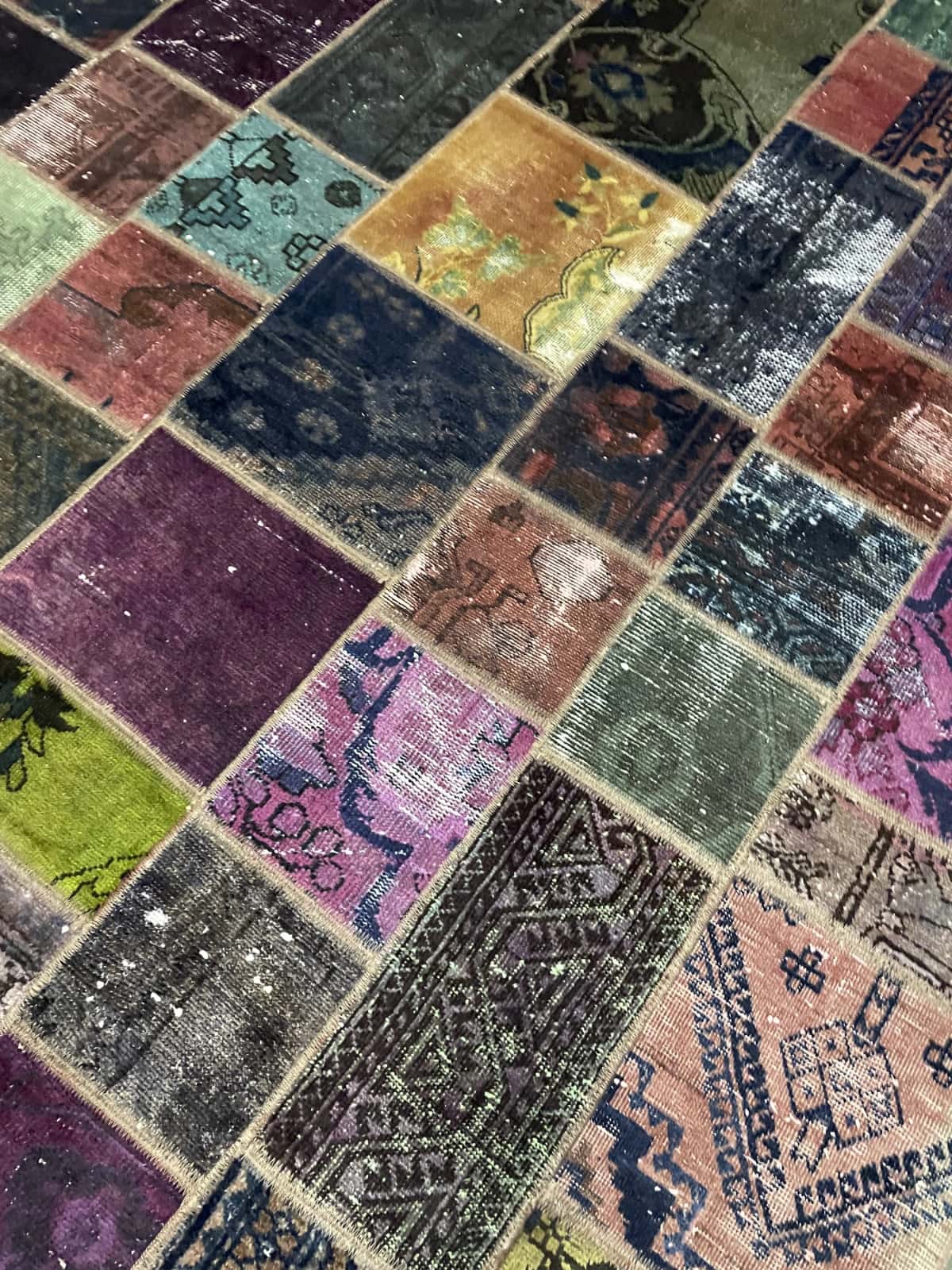 Persian rug of Patchwork style in dimensions 220 centimeters length by 168 centimeters width with mainly colorful colors — Texture close-up